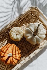Kaboompics - White and Orange Pumpkins in a Wicker Tray with Sunlight