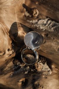 Kaboompics - Close-Up Silver Ring with a Smooth Gray Stone on Weathered Wood