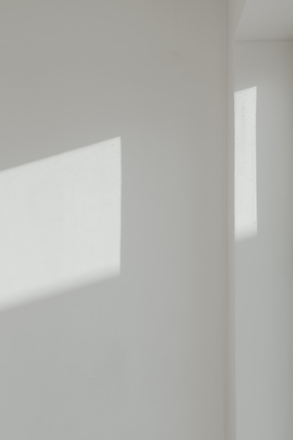 Minimal photograph of angled daylight and shadow on a pale wall