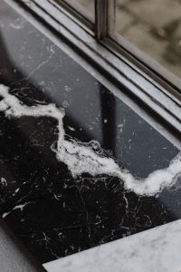 Kaboompics - Black Marble by Window with Bold White Vein - Reflective Stone Background