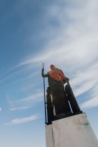 Kaboompics - Backlit Silhouette of a Madrid Rooftop Statue Against Wispy Blue Sky