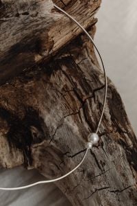 Kaboompics - Silver Pearl Necklace on Weathered Wood, Minimal Still Life