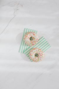 Kaboompics - Donuts on paper napkins placed on white marble