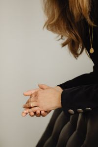 Kaboompics - Woman Clasping Ringed Hands Beside Black Chair
