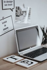 Kaboompics - Laptop Keyboard Beneath Motivational Graphic Design Quotes and Monochrome Street Print