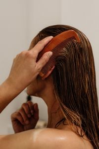Kaboompics - Woman Combing Wet Hair with a Brown Comb