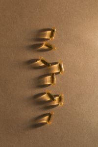 Kaboompics - Dietary Supplements and Capsules Styled on a Black Leaf