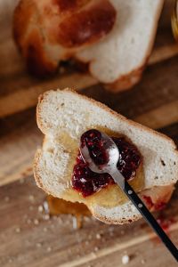Kaboompics - Hands Slicing Powdered Challah on Wooden Board