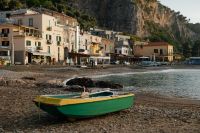Kaboompics - Green Fishing Boat on Pebble Shore with Marina di Puolo Village in Background
