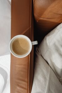 Kaboompics - Coffee in a White Mug on Cognac Leather with Linen Texture for Warm Brand Backgrounds