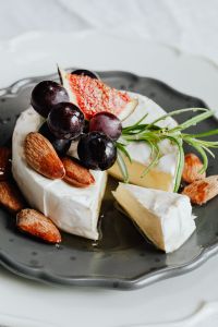 Kaboompics - Camembert Wedges with Grapes, Figs and Almonds on Black Plate