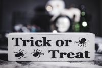 Kaboompics - Trick-or-Treat Sign with Spider Graphics and Blurred Halloween Candy Background
