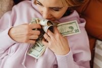 Kaboompics - Faceless Woman Looking at Dollar Bills on a Sofa