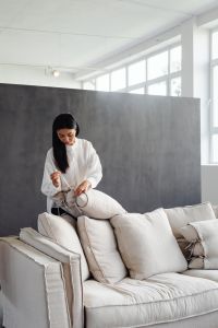 Kaboompics - Woman Repositioning Cushions on a Sofa