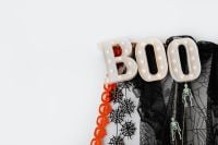 Kaboompics - Halloween BOO Sign with Spiderweb Cloth and Hanging Skeletons