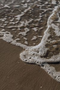 Kaboompics - Minimal White Foam Line on Wet Sand, Beach Background