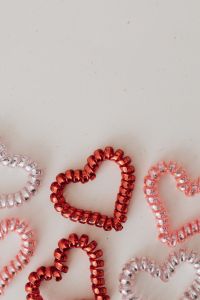 Kaboompics - Vertical Flat Lay of Red, Pink and Pearl Beaded Hearts on Beige Background