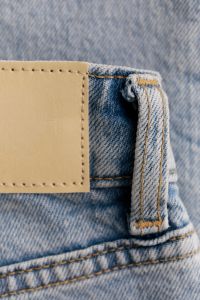 Kaboompics - Blank Tan Jeans Patch and Belt Loop on Light Wash Denim, Vertical Close-Up