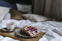 Kaboompics - Breakfast Tray with Raspberry Waffles, Coffee and Soft Bedroom Pillows
