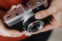 Kaboompics - Close-Up of Hands Cradling an Olympus Trip 35 Lens