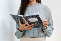 Kaboompics - Close-Up of Asian Woman Holding an Open Notes Notebook