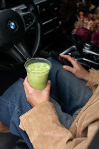 Kaboompics - Woman Holding Matcha and a Smartphone in a Car