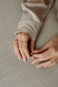 Kaboompics - Woman Arranging Pearl Jewelry on Fabric
