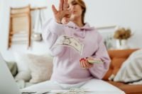Kaboompics - Woman Holding Dollar Bills in a Living Room