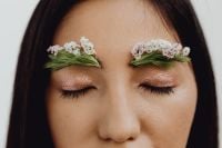 Kaboompics - Closed Eyes with Sparkling Pink Makeup and Paired Greenery Eyebrows Topped with White Flowers