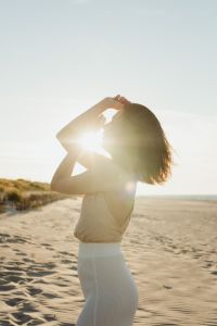 Kaboompics - Woman Shielding Her Eyes from the Sun on a Beach at Sunset