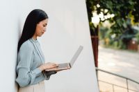 Kaboompics - Asian Woman Working Remotely on a Pink Laptop Outdoors