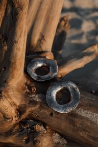 Kaboompics - Large Silver Hoop Earrings on Driftwood, Coastal Jewelry Still Life