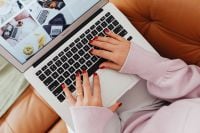 Kaboompics - Faceless Woman Typing on a Laptop from a Sofa
