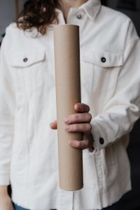Kaboompics - Person Holding a Kraft Cardboard Tube Upright Against a White Corduroy Shirt