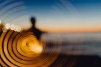 Kaboompics - Light painting. The man waving fairy lights at the sea at sunset.
