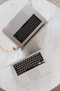 Kaboompics - Two Silver Laptops Arranged Diagonally on White Textured Surface
