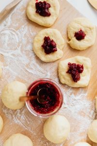 Kaboompics - Cherry-Filled Paczki Dough Rounds Beside a Jam Jar