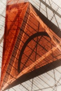 Kaboompics - Red Triangle Ruler on Geometric Grid Background