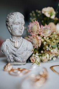 Kaboompics - Gold jewellery in white marble - flowers and a small sculpture, a shell