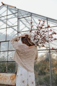 Kaboompics - A beautiful tall woman holds cotton branches