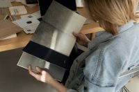 Kaboompics - Designer Comparing Surface Finishes in a Material Sample Catalog