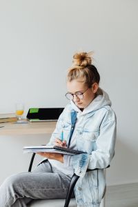 Kaboompics - Teenage Student Writing Homework in Notebook