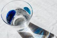 Kaboompics - Top-Down Sparkling Water Glass with Blue Reflections on White Linen, Beverage Flat Lay