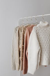 Kaboompics - Neutral Sweater Collection Hanging in Bright Room