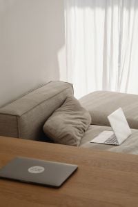 Kaboompics - Remote Work Setup with Two Laptops, Neutral Sofa and Wooden Coffee Table