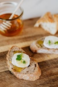 Kaboompics - Goat Cheese Crostini With Honey and Mint on Wooden Board