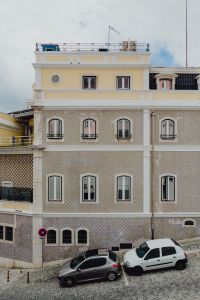 Kaboompics - Yellow Upper Story over Diamond-Tiled Lisbon Facade with Parked Cars