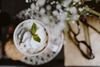 Kaboompics - Close-Up of Whipped Cream Coffee with Fresh Mint, Cookie and Eyeglasses in Soft Focus