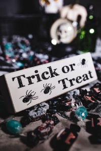 Kaboompics - Vertical Trick-or-Treat Sign with Spooky Candy and Skull Globe