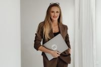 Kaboompics - Female Interior Stylist Standing With Laptop in Brown Suit